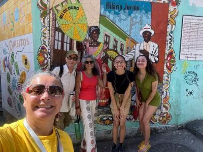 Selfie of Rio Free Walking Tour's Tour Guide Leticia and some Tourits in front of a paiting in Santa Teresa neighborhood.